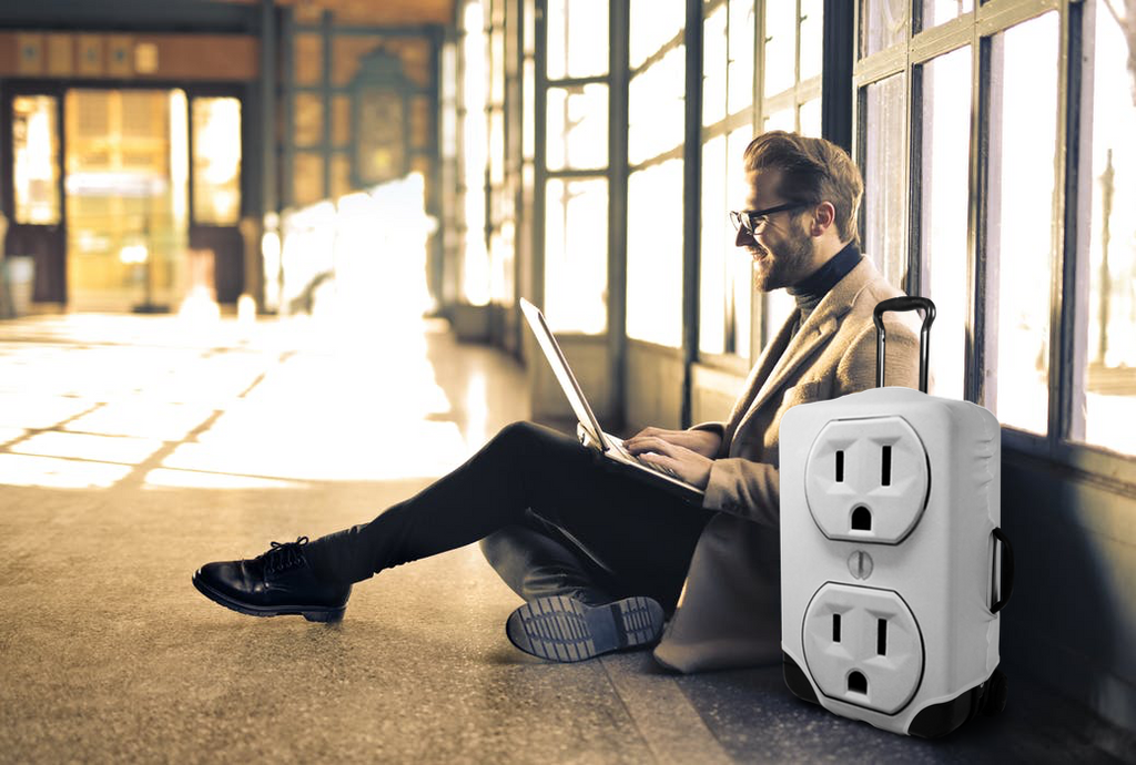 Man sits in airport terminal with outlet suitcase cover